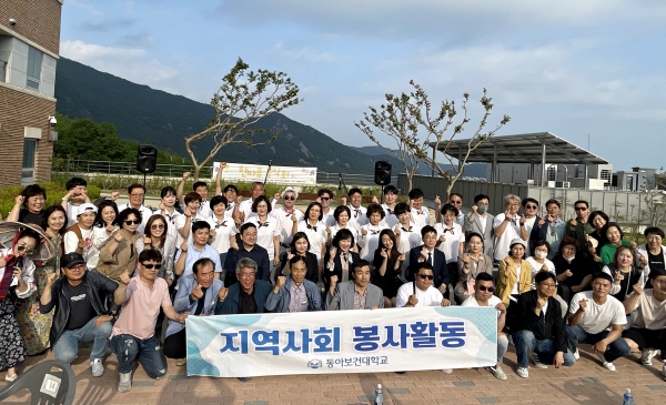 동아보건대학교 교수와 학생들이 현수막(지역사회 봉사활동 동아보건대학교)을 들고 단체 기념촬영을 하는 모습